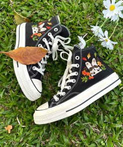 a2 Converse embroidered raccoons are super cute in the middle of a colorful flower garden.
